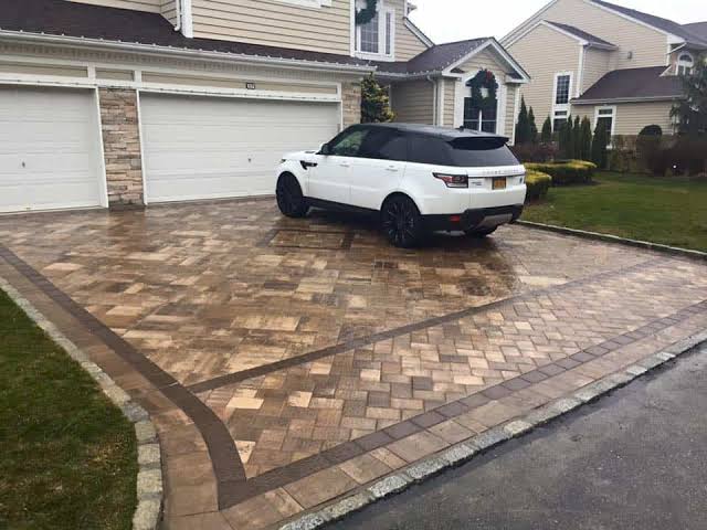 Completed paver driveway installation with patterned border.